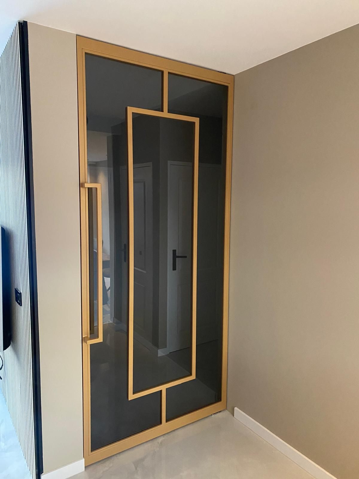 Stalen taatsdeur met gouden poedercoating en getint glas