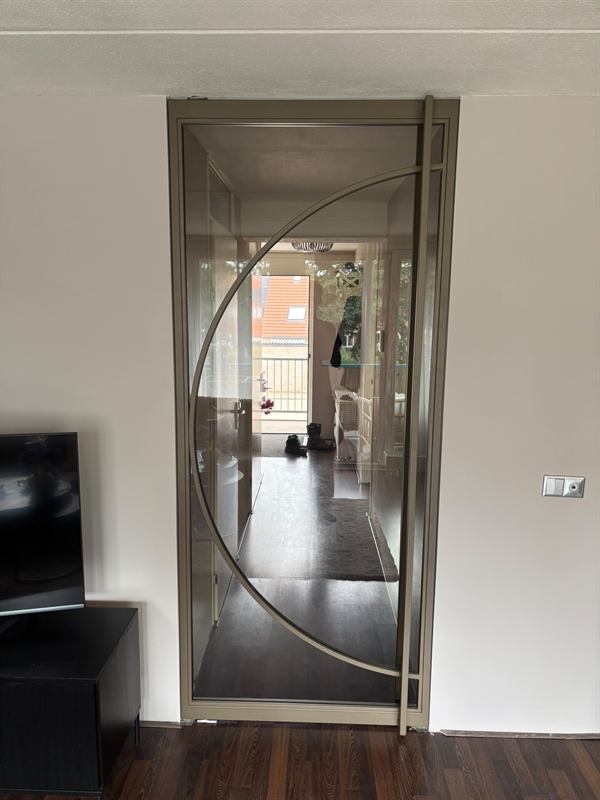 Taatsdeur met halve ronding en bronzen afwerking