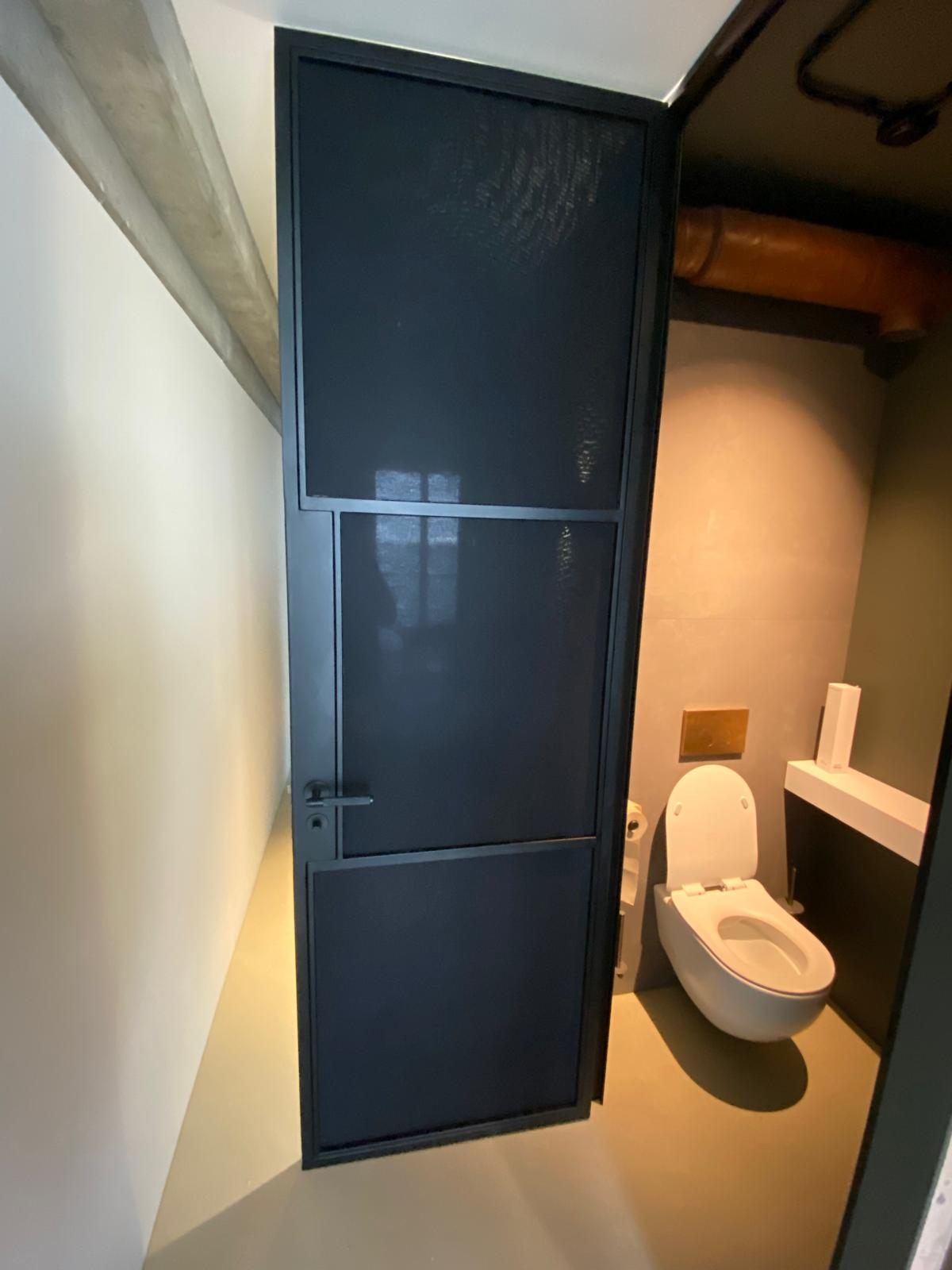 Stalen scharnierdeur bij het toilet