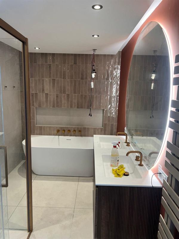 Badkamer met vrijstaand bad en gouden kranen