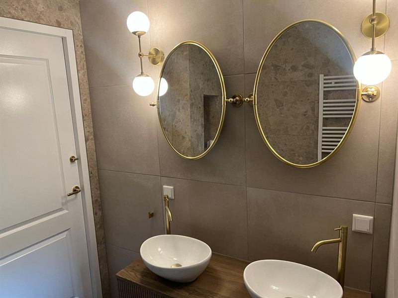 Badkamer met dubbele ovale spiegels in messing